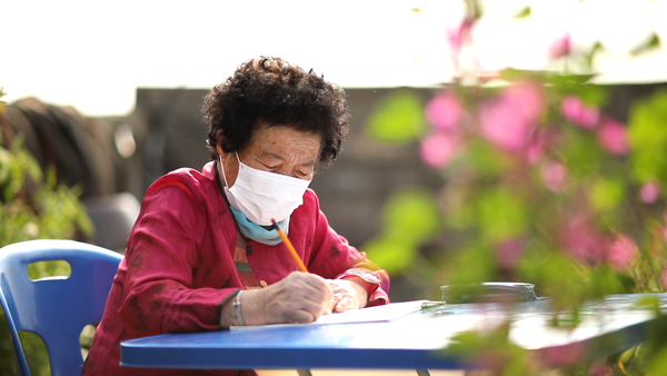 일기를 쓰고 있는 이백임 어머님의 모습.