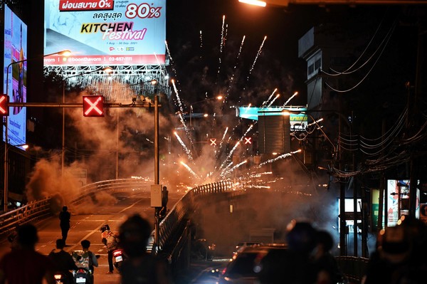 사진=AFP/연합뉴스, 경찰에 폭죽을 발사하는 시위대