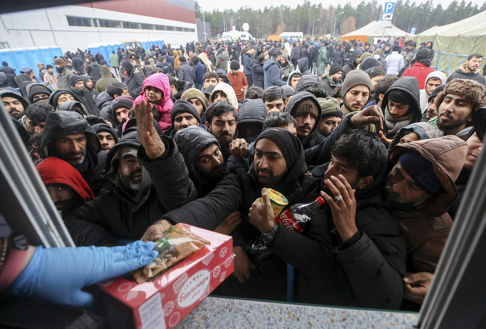 [사진=벨라루스 측으로부터 음식을 배급받고 있는 난민들, TASS/연합뉴스]