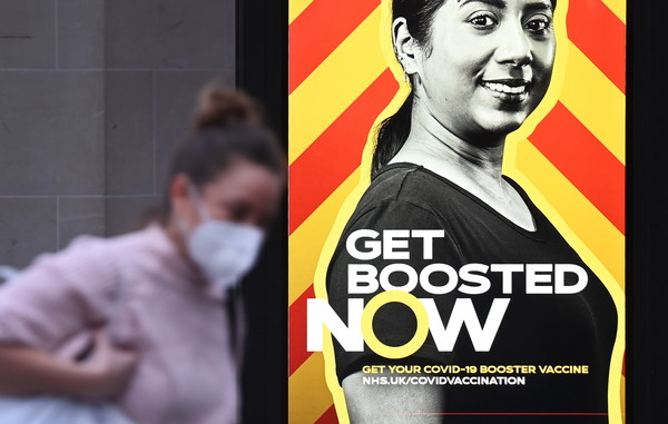 [사진=부스터샷 홍보물 앞을 지나고 있는 영국 런던의 한 행인, EPA/연합뉴스]