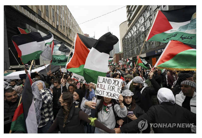 캐나다 토론토에서 팔레스타인 지지자들이 행진하며 시위를 펼치고 있다/사진=연합뉴스